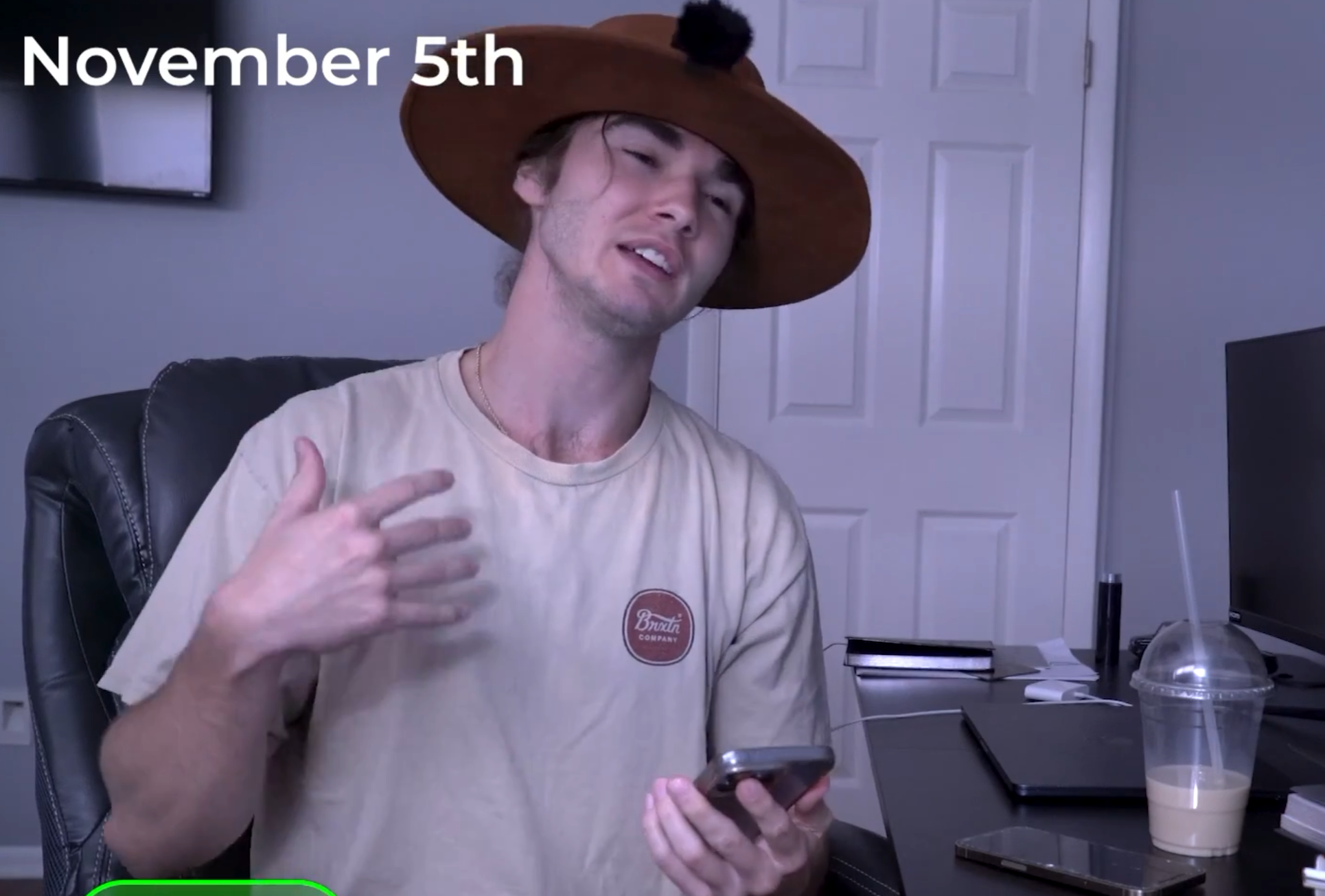 A man in a novelty hat holding a phone