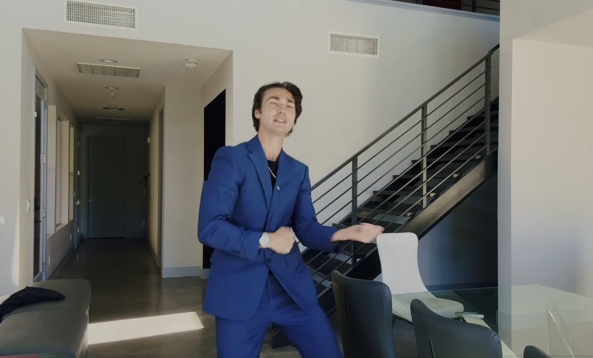 A man in a blue suit presenting in an empty modern room